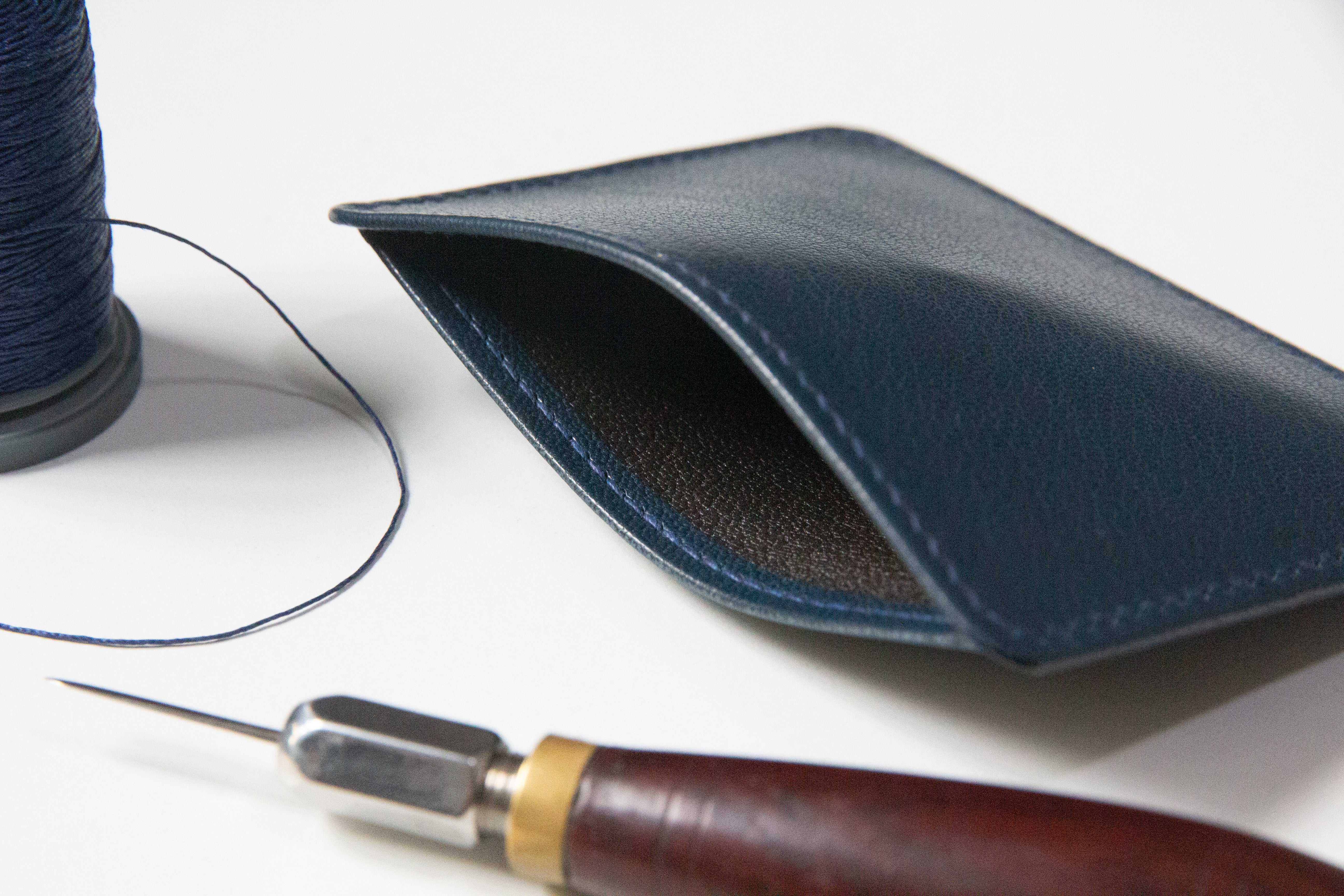 Slim 3 pocket card wallet, showing internal lining and stitching tools.